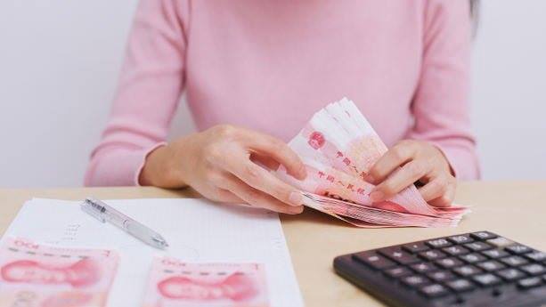 A pink shirt officer working in a China logistic company in Malaysia is counting a lot of money.
